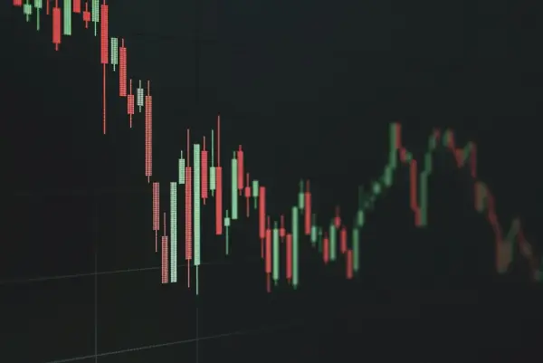 Candlestick stock chart on a dark screen showing a declining trend