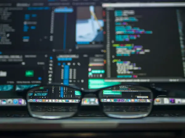 Eyeglasses in front of a laptop screen full of code