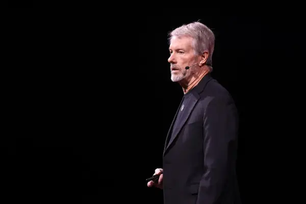 Michael Saylor in profile on a dark stage at Bitcoin 2025