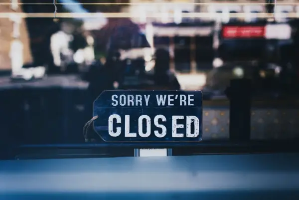 Sorry We're Closed sign hanging in a shop window