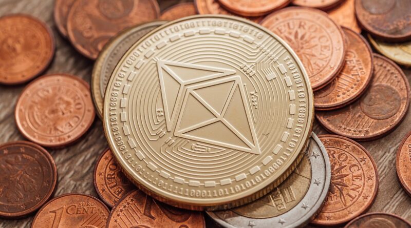 Close-up of a physical Ethereum coin resting on a pile of regular coins
