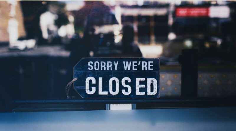 Sorry We're Closed sign hanging in a shop window