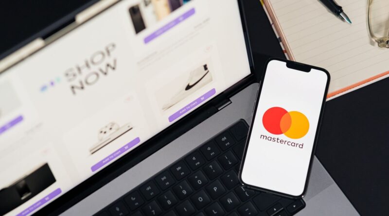Smartphone showing the Mastercard logo resting on a laptop keyboard