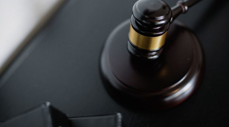 Wooden judge's gavel on a courtroom table near case folders