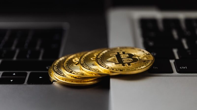 Gold bitcoin coins resting on laptop keyboards